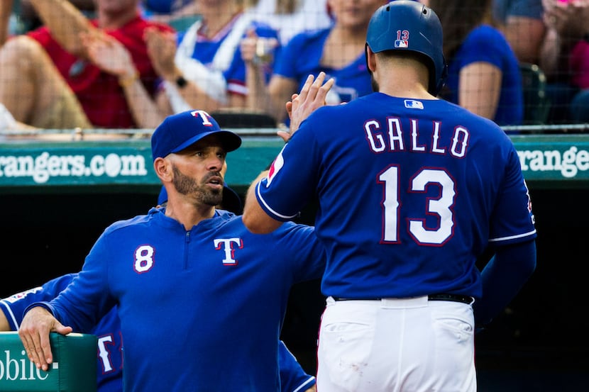 Texas Rangers center fielder Joey Gallo (13) gets a high-five from manager Chris Woodward...