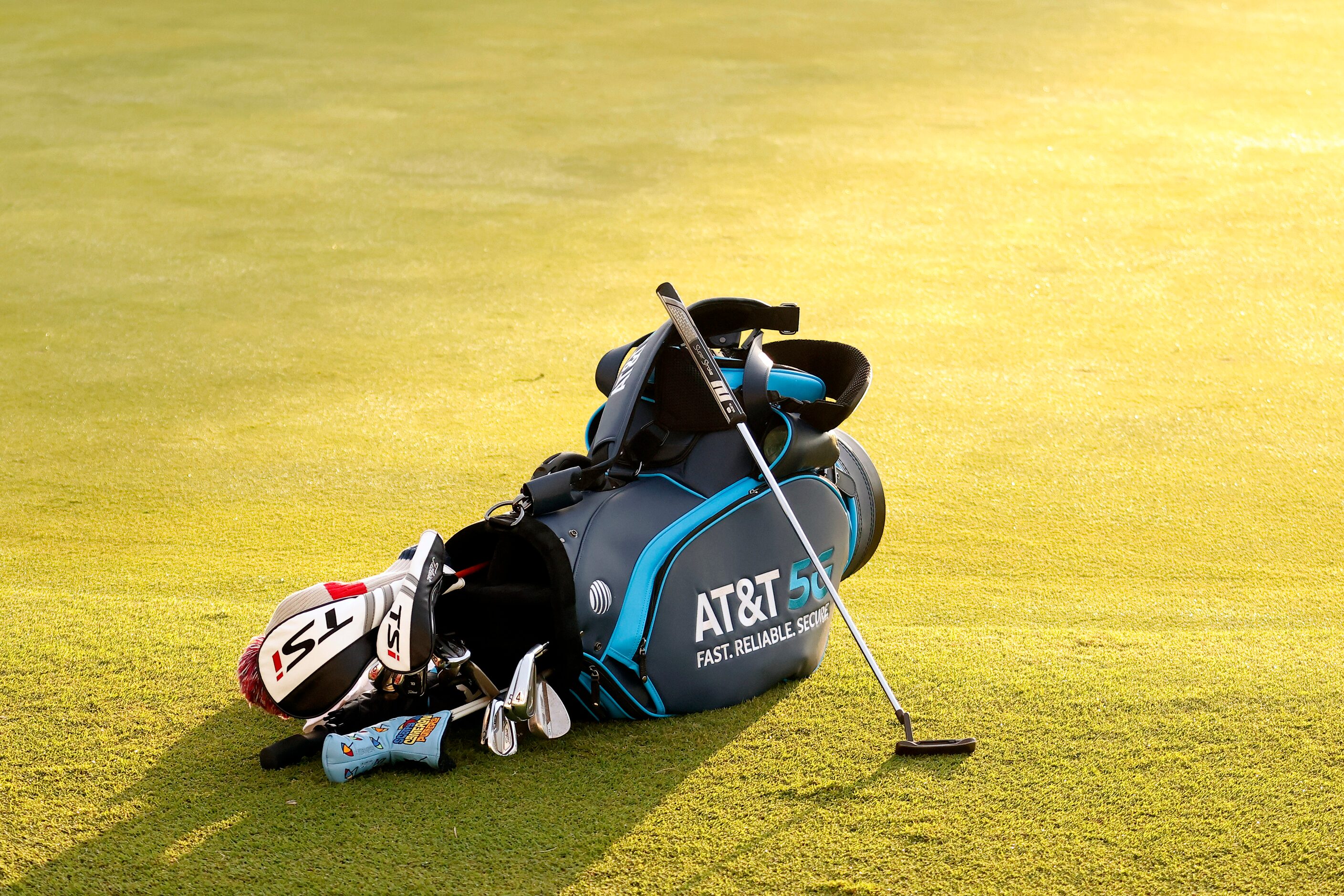 Professional golfer Jordan Spieth's putter and bag lie along 18th green during round two of...