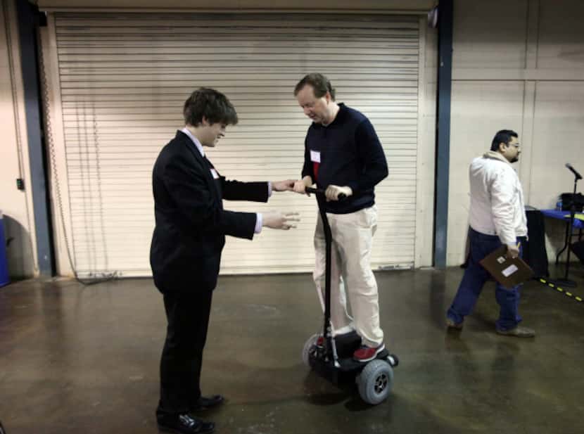 Electrical engineer Paul Hylander, right, rides a version of a Segway designed by Bishop...