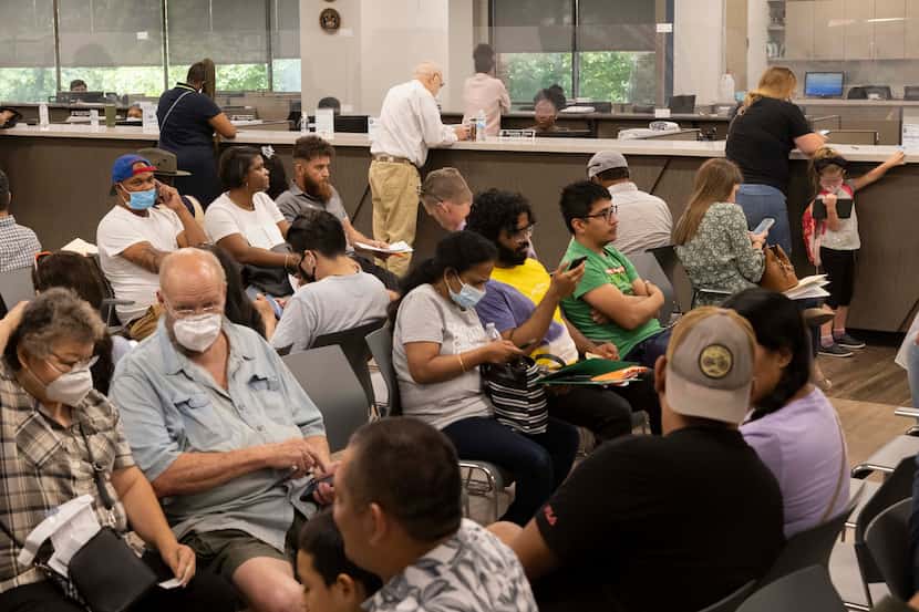 People wait for their number to be called at the Dallas County Tax Office located in the...