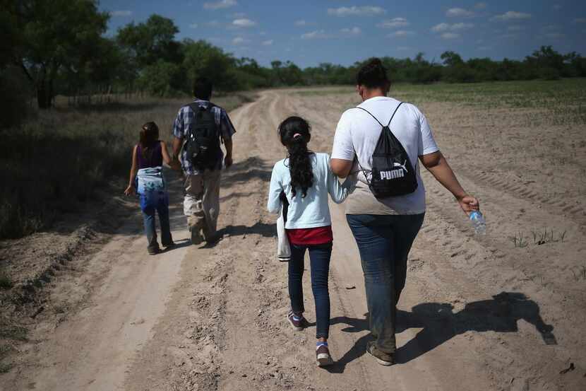 Familias centroamericanas recorren un camino rural luego de cruzar a Estados Unidos en busca...