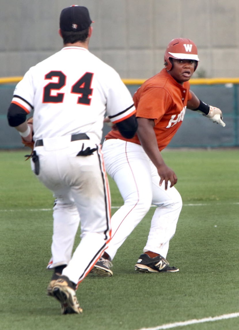 W.T. White outfielder Darryl Matthews (18) applies the brakes as he becomes caught in a...