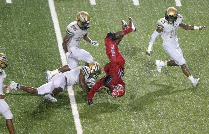 Cedar Hill's Kolbi McGary (31) is flipped after getting tackled by DeSoto's Caleb Abrom (10)...