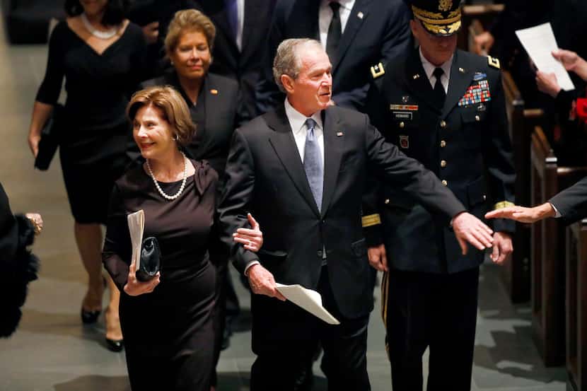 Former President George W. Bush and First Lady Laura Bush are greeted by well-wishers during...
