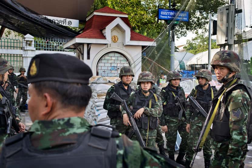 Soldiers stand guard on the street near the Government House in Bangkok. Leading members of...