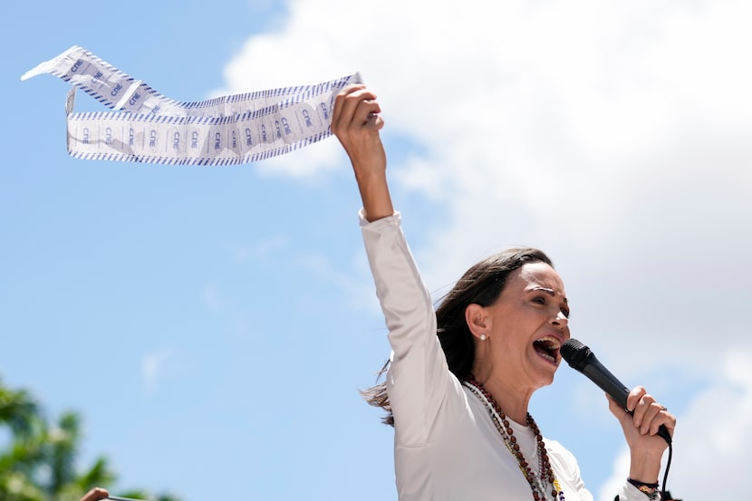 Opposition leader Maria Corina Machado holds up tally sheets during a protest against the...