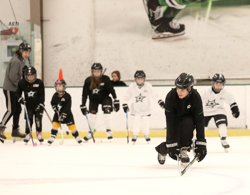 Allysen Weidner demonstrates how to recover from a fall as girls practice their hockey...