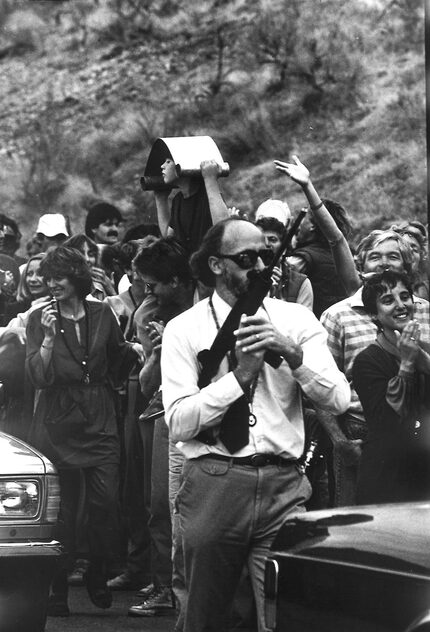 Nov. 9, 1984: A guard carrying what appears to be a submachine gun follows the guru's car.