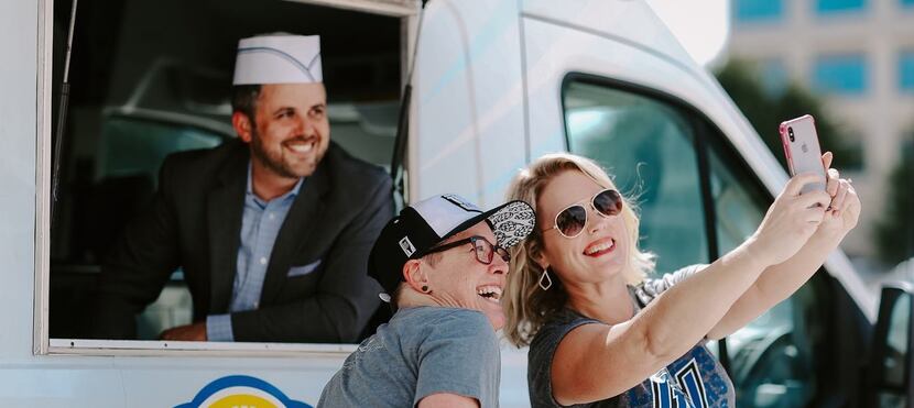 Workers at health care staffing company AHSG take a selfie in front of an ice cream truck...