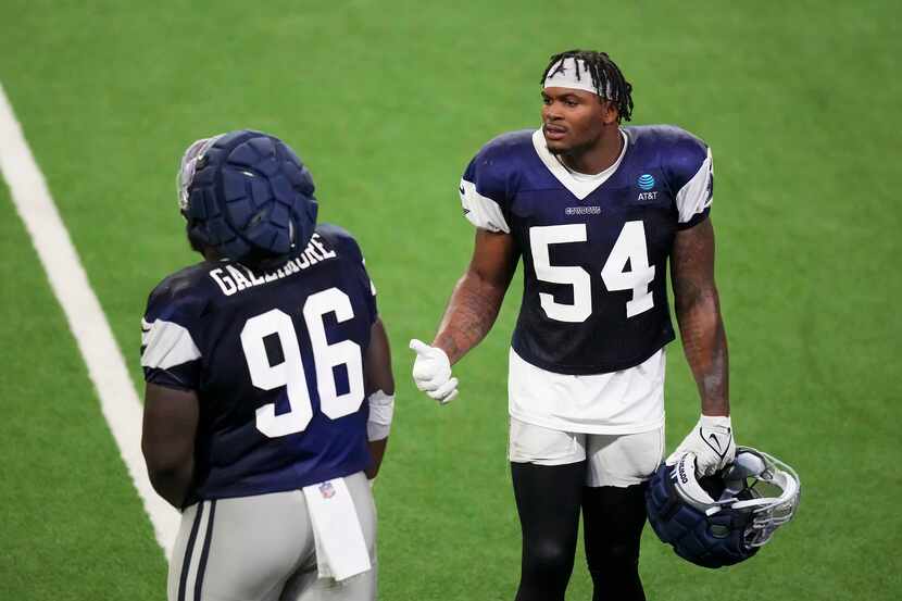 Dallas Cowboys defensive end Sam Williams (54) talks with defensive tackle Neville Gallimore...