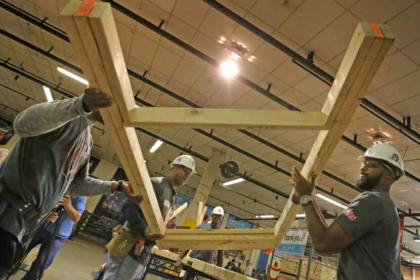 MLB player Chris Young, right, gets some help placing part of a frame Wednesday, Nov. 29,...