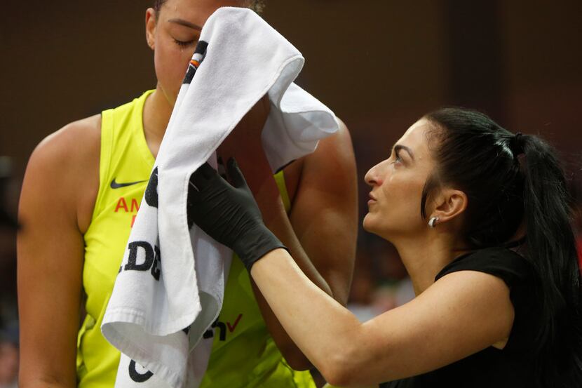Dallas Wings center Liz Cambage (8) receives medical assistance from team athletic trainer...