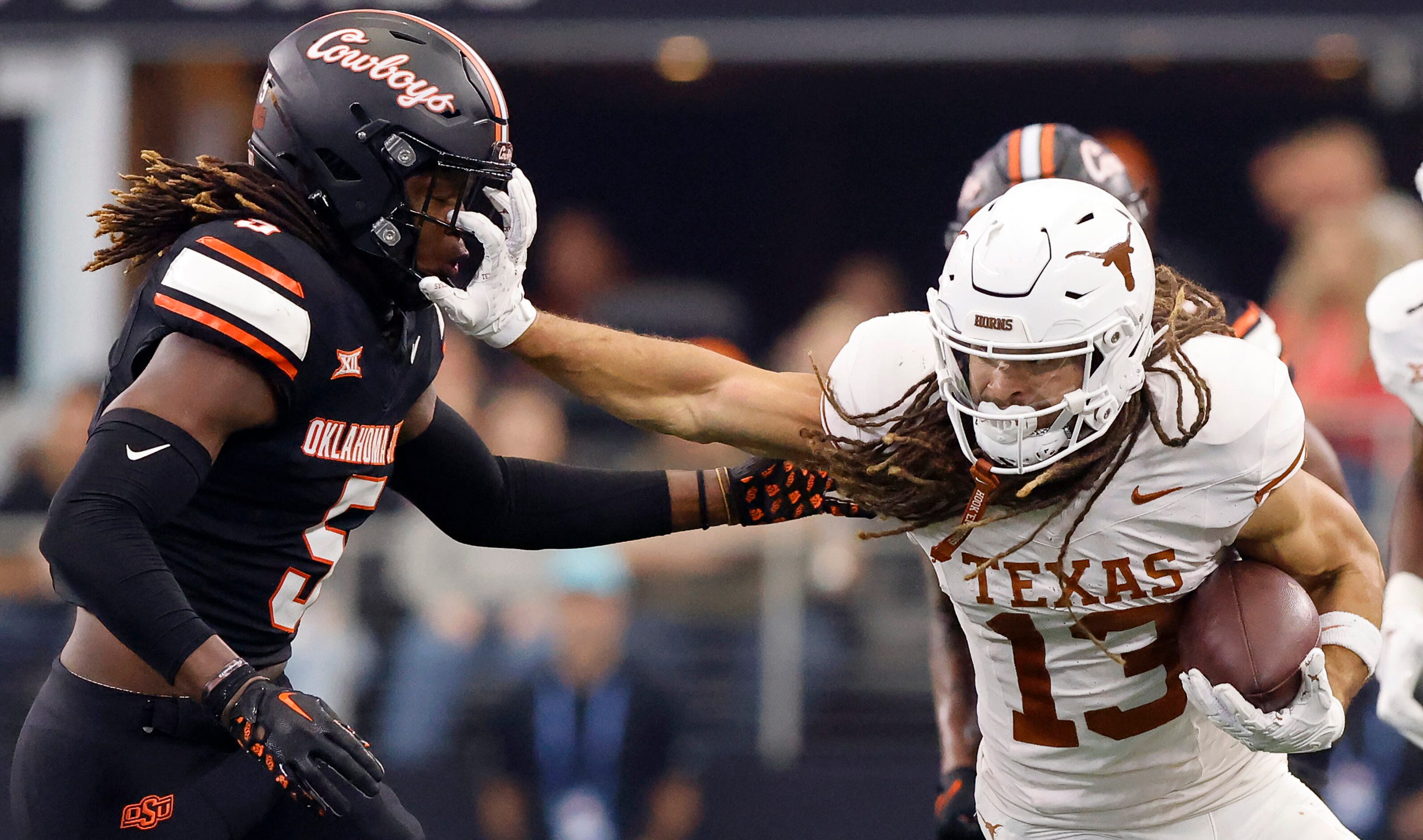 Texas Longhorns wide receiver Jordan Whittington (13) gives a stiff arm to Oklahoma State...