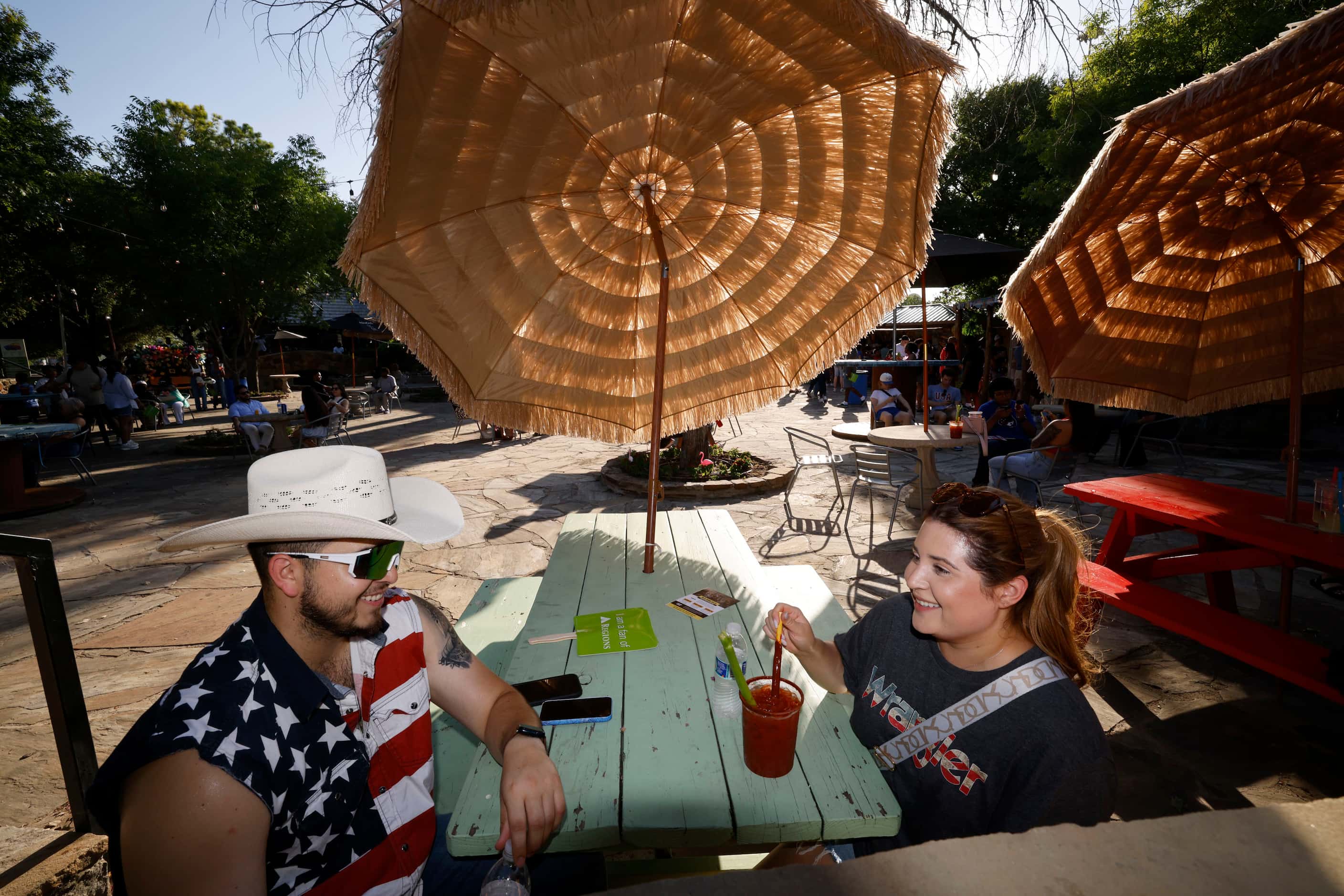 Isaac Escarsega of Dallas sits down under a parasol with his girlfriend Jackie Aguirre...