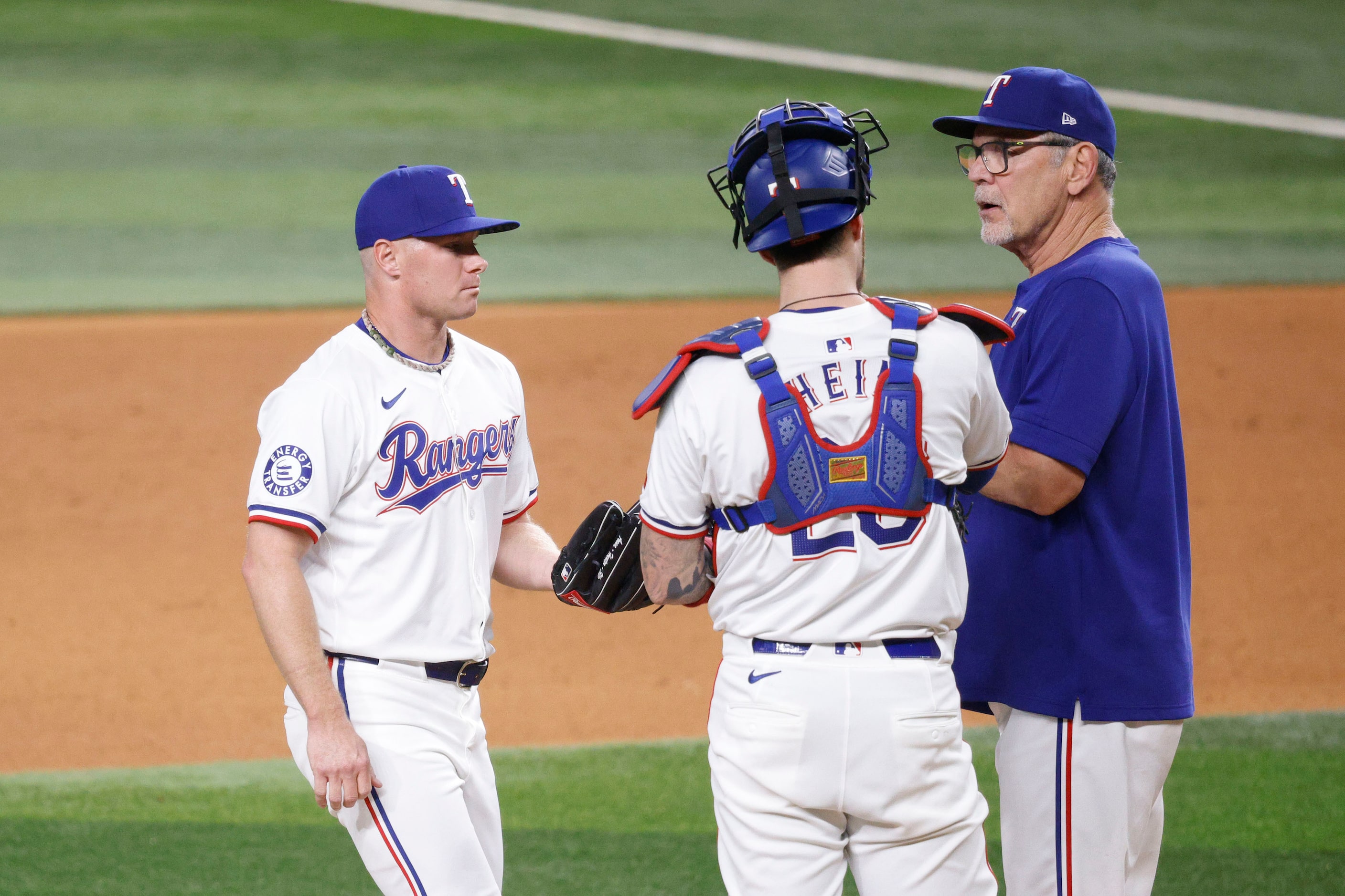 Texas Rangers pitcher Chase Anderson (45), left, receives a ball from Texas Rangers manager...