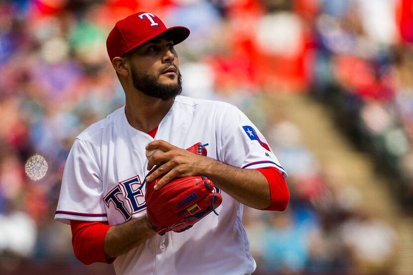 Texas Rangers starting pitcher Martin Perez looks back to the stands after giving up a run...