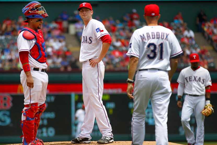 Texas Rangers starting pitcher Ross Detwiler (47) receives a visit to the mound by pitching...