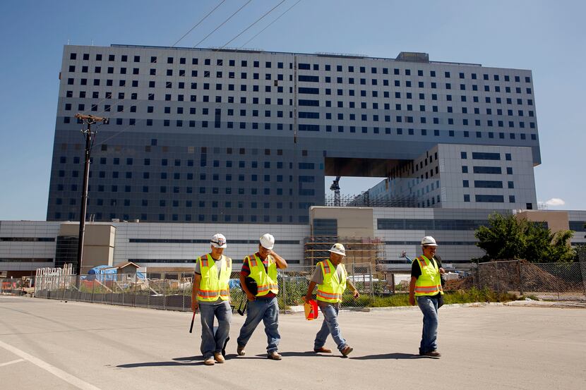Laborers walk away from the construction area of the new Parkland Memorial Hospital.