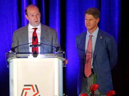 Dan Hunt (left) speaks from the podium while his brother Clark Hunt looks on during the...