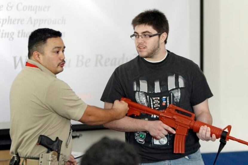 
North Lake College police Officer Joe Santos and Gabriel Garcia, 18, demonstrate how and...