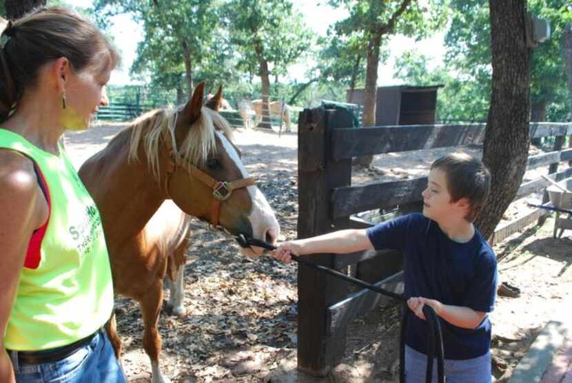 
Nicholas Molencupp, 9, guides his riding partner Socks through a gate as senior instructor...