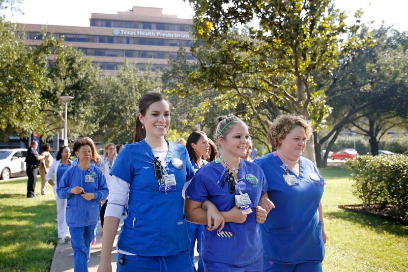 
Texas Health Presbyterian nurses walk arm in arm on their way to a press conference...