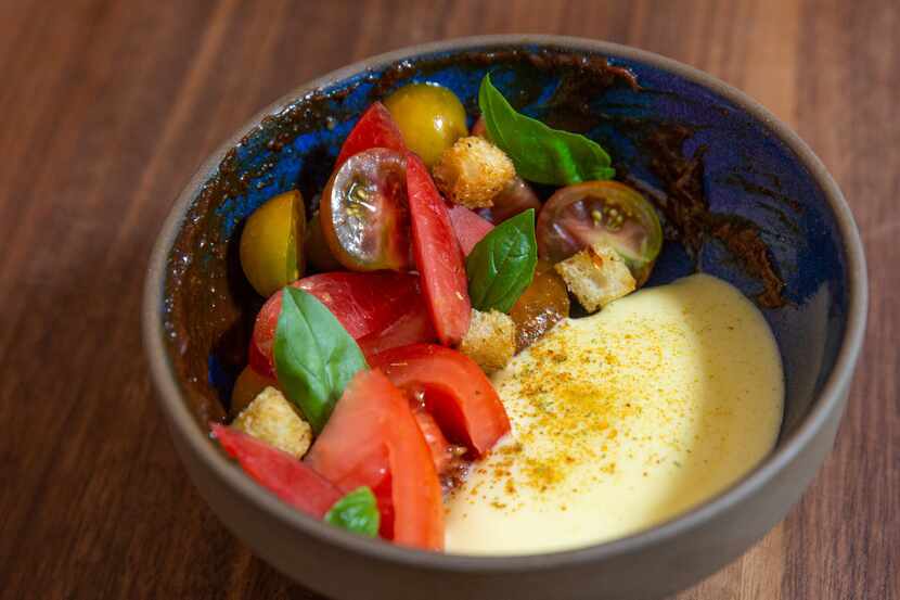 The dish called tomatoes and plums is dressed with fluffy aerated olive oil and a swipe of...