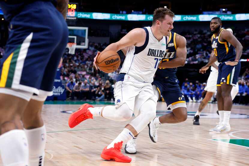 El jugador de los Mavericks de Dallas, (izq), conduce el balón contra el Jazz de Utah...