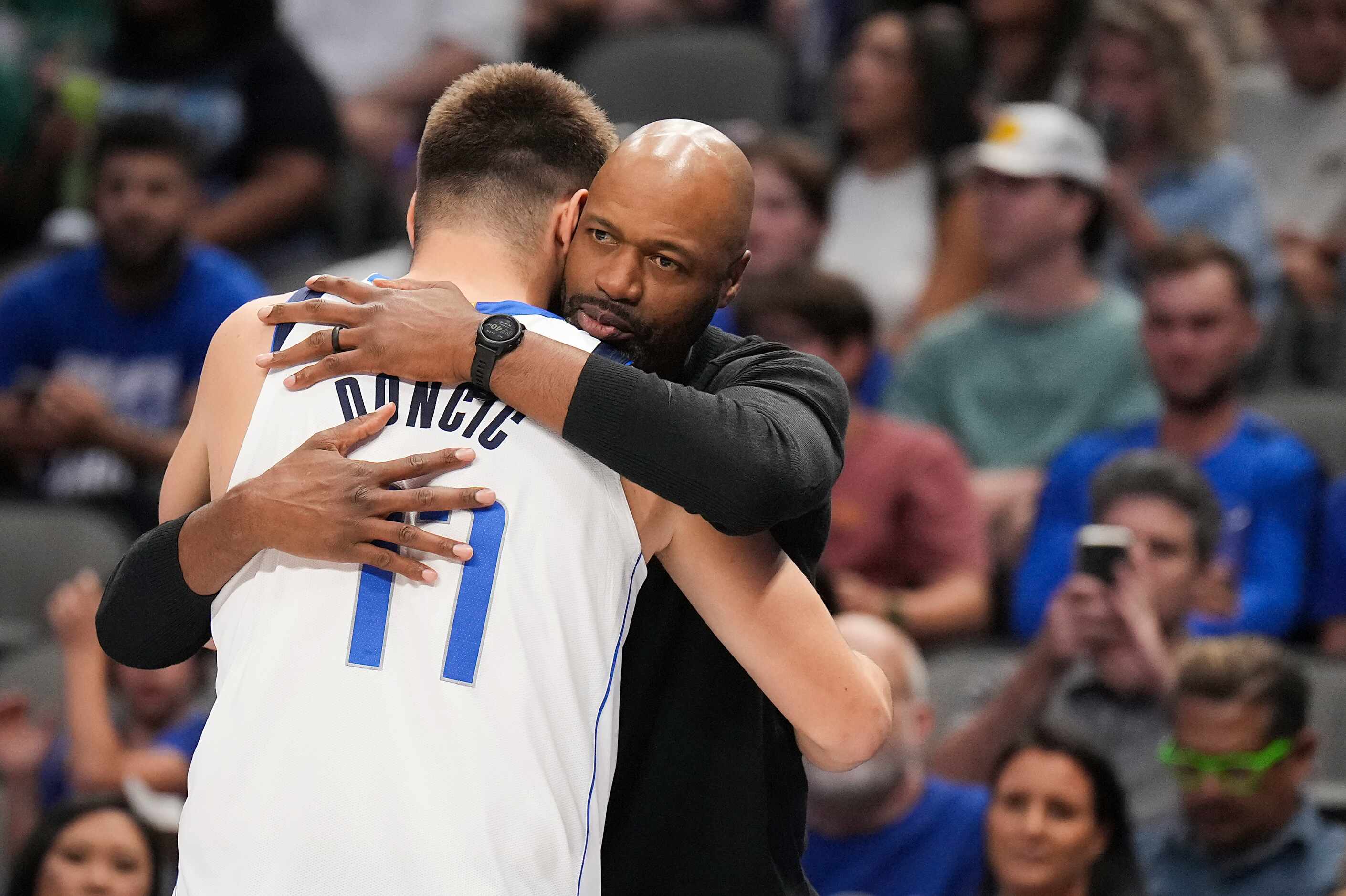 Orlando Magic coach Jamahl Mosley hugs Dallas Mavericks guard Luka Doncic before an NBA...