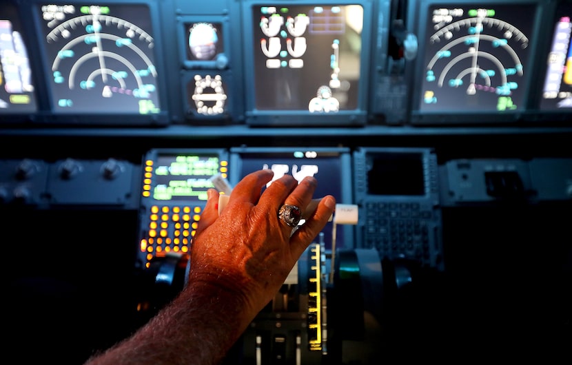 Kevin Sayre has his hand on the throttle in his flight simulator he built in his garage, at...