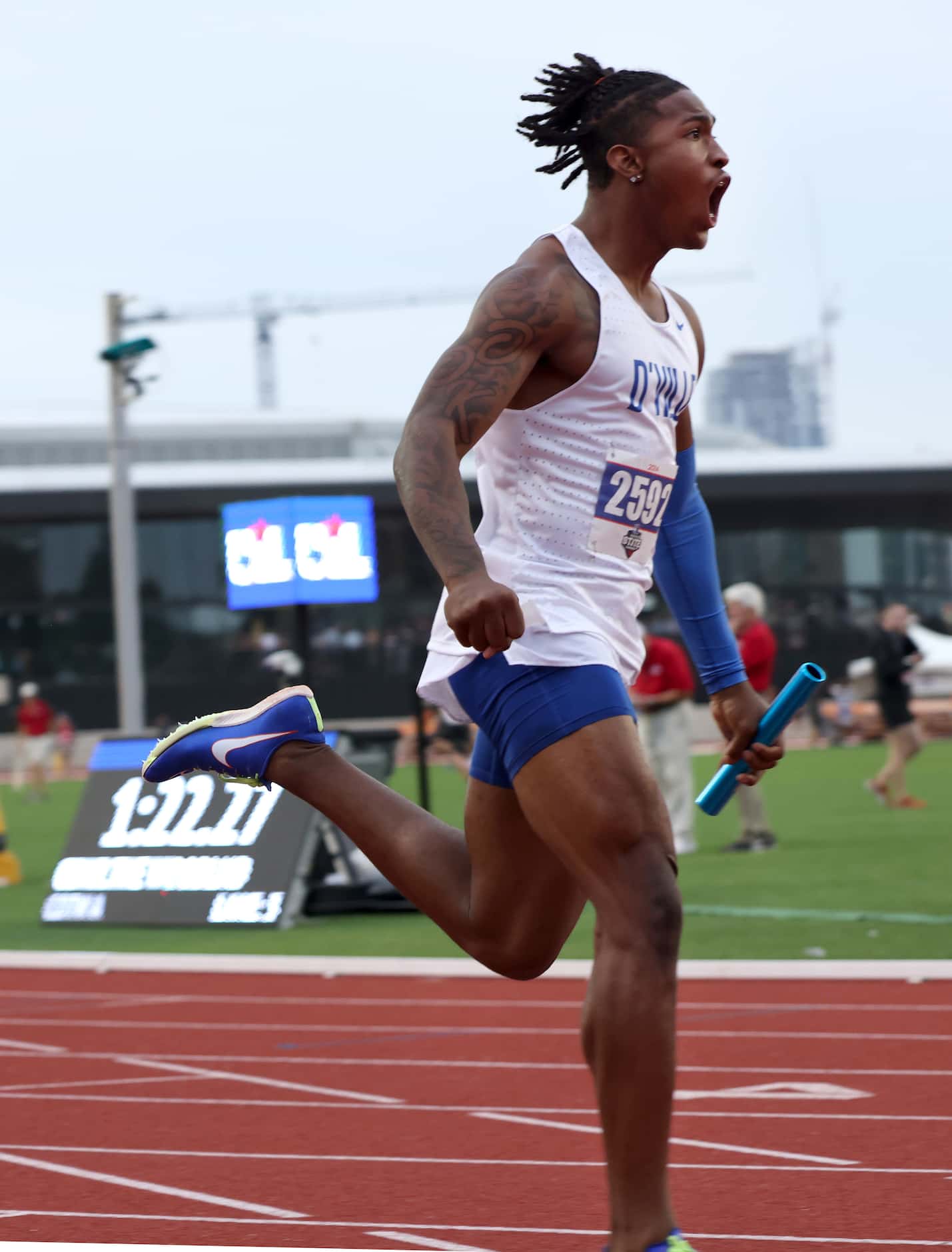 Duncanville anchor Dakorien Moore lets out a yell after crossing the finish line first as...