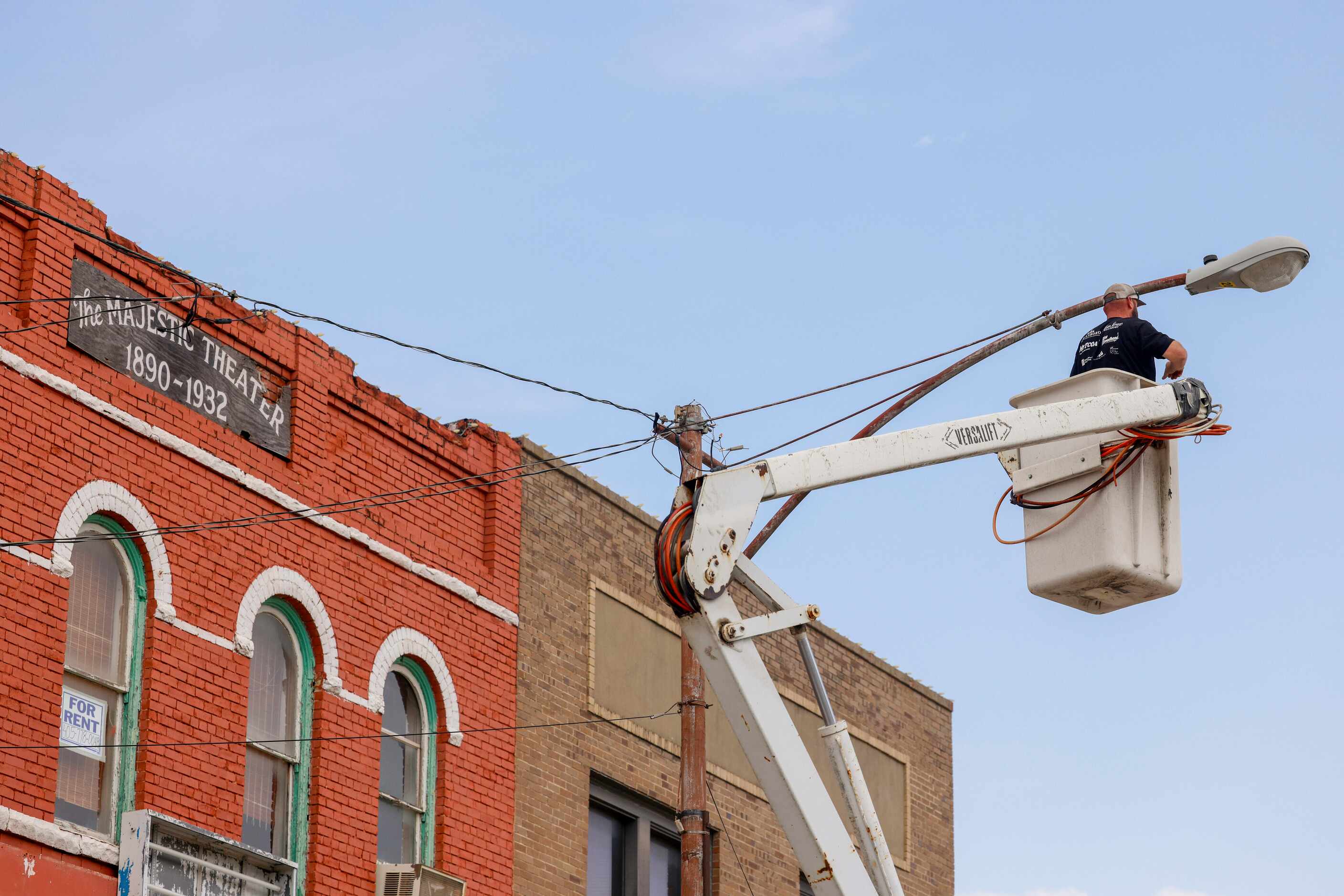 Equipment operator Bobby Barnes works to reconnect street lights that were turned off during...