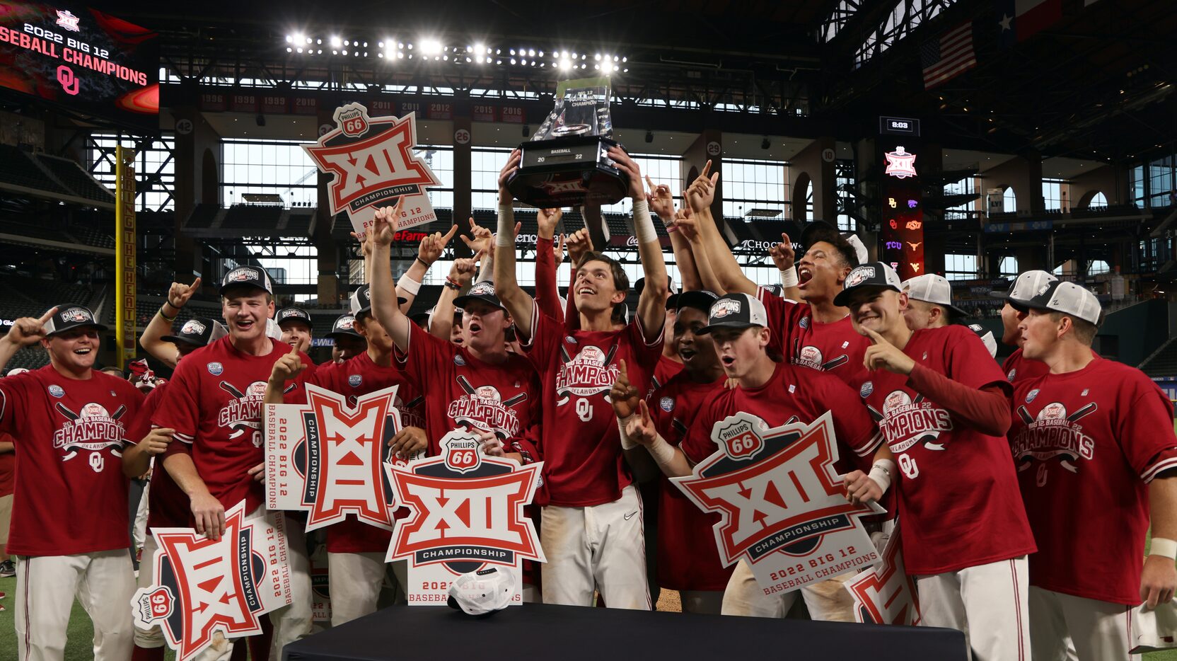 Oklahoma Sooners infielder Peyton Graham, center, hoists the Big 12 tournament championship...