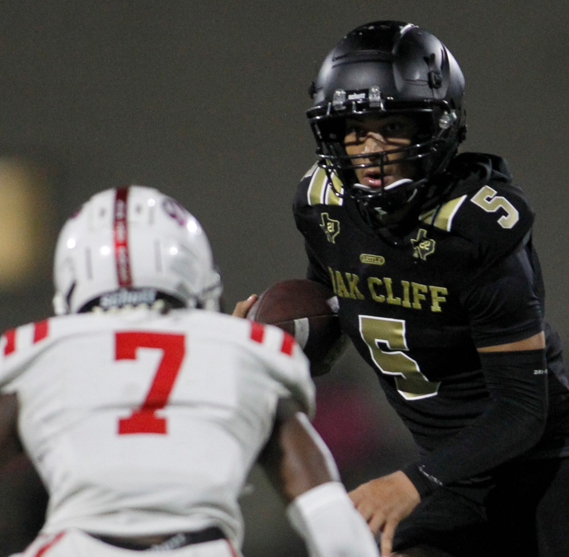 South Oak Cliff quarterback Reggie McNeal (5), right, eyes the defense of Duncanville...