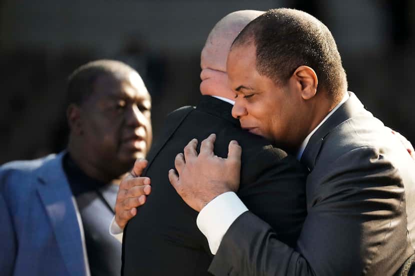 Dallas Mayor Eric Johnson hugs another mourner as he arrives for funeral services for former...