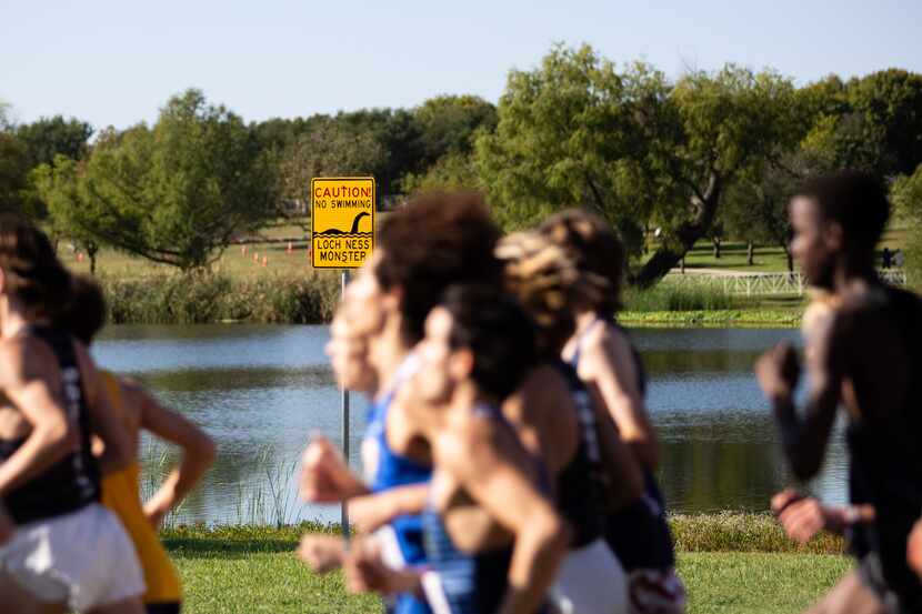 Competitors in the 5A boys’ 5k race run through Old Settlers Park during the UIL Cross...
