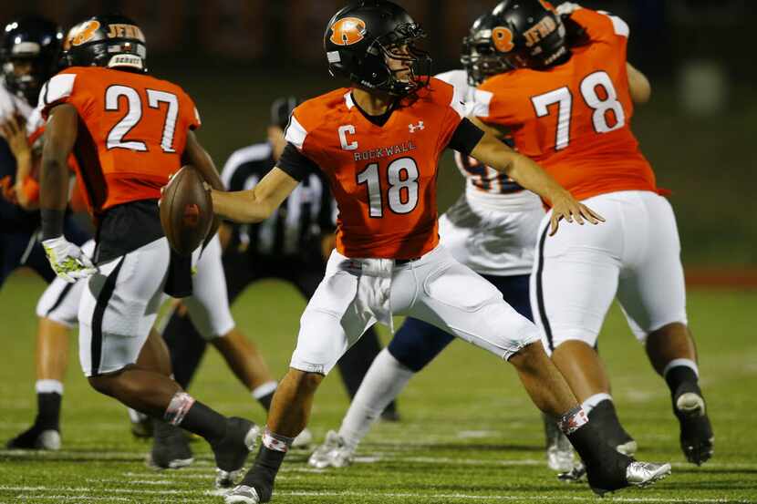 TXHSFB Rockwall quarterback Will Reed (18) passes as running back Caleb Broach (27) and...