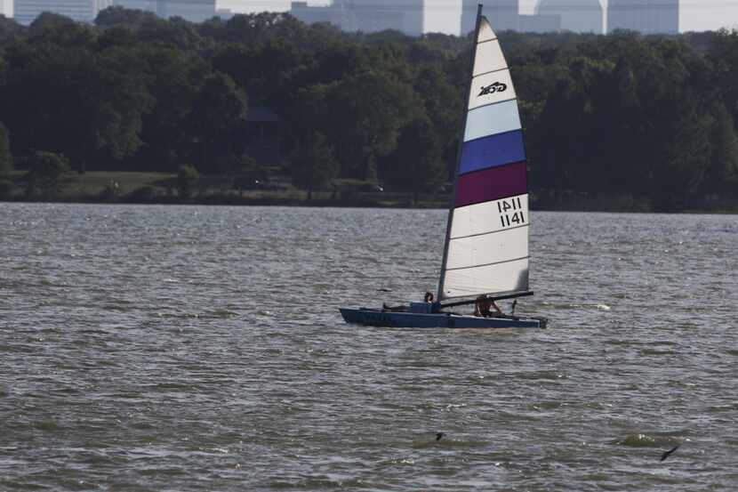 A sail boat navigates an almost empty White Rock Lake in Dallas late Saturday afternoon July...
