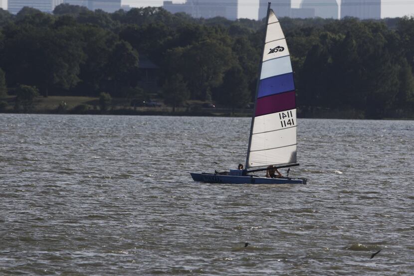 A sail boat navigates an almost empty White Rock Lake in Dallas late Saturday afternoon July...