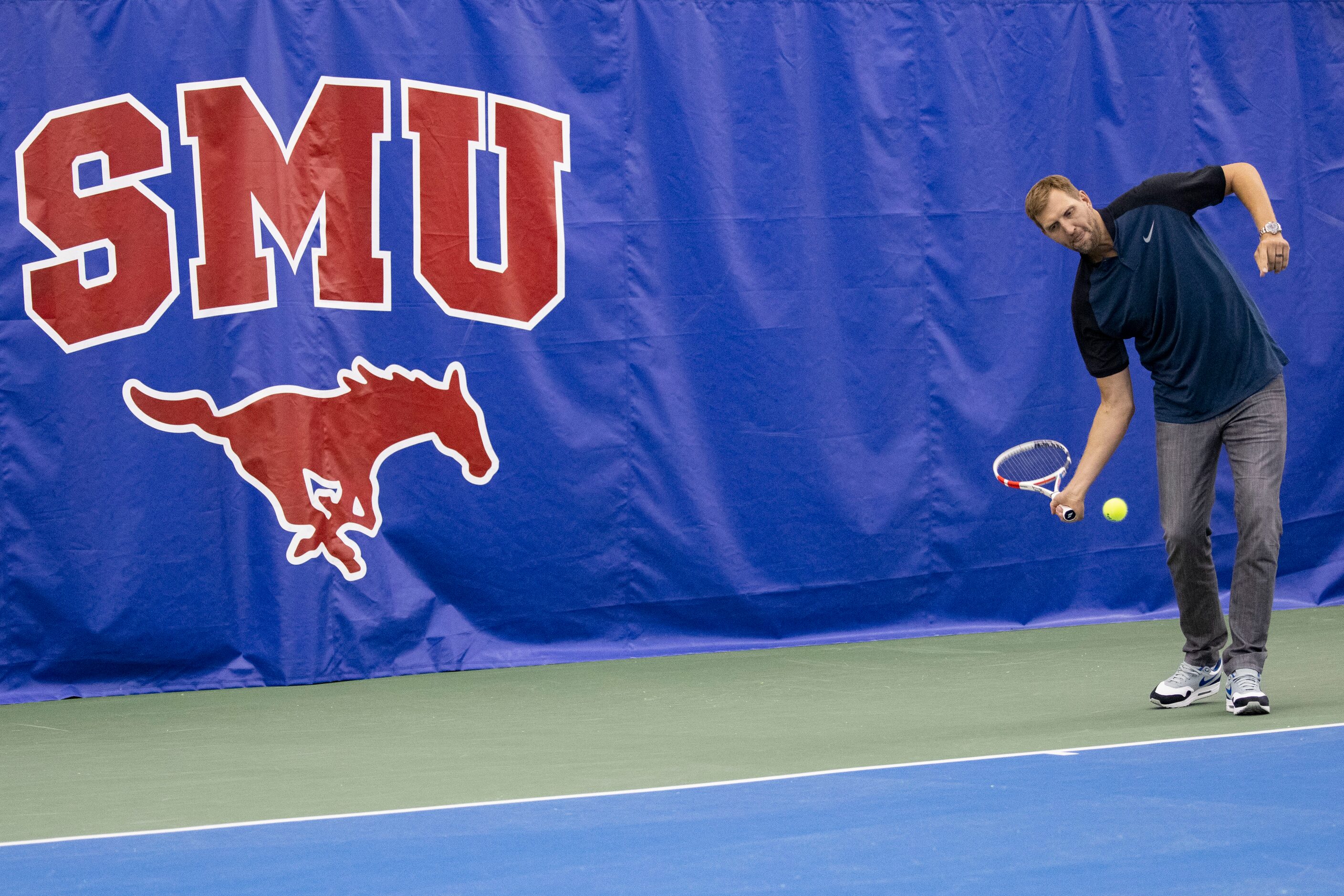 Dallas Mavericks star Dirk Nowitzki hits the tennis ball to John Isner, 15-Time ATP Tour...