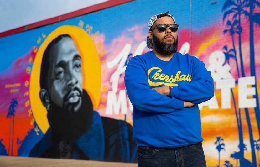 Dallas artist Jeremy Biggers poses in front of his mural dedicated to the late rapper,...