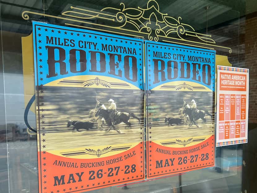 A poster for a Montana rodeo hangs in the window of a local business on Tuesday.