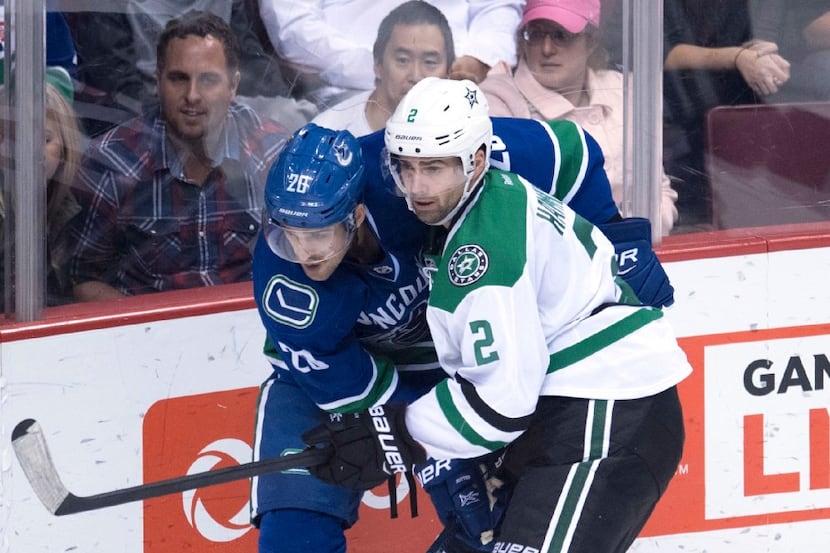 Dallas Stars defenseman Dan Hamhuis (2) fights for control of the puck with Vancouver...
