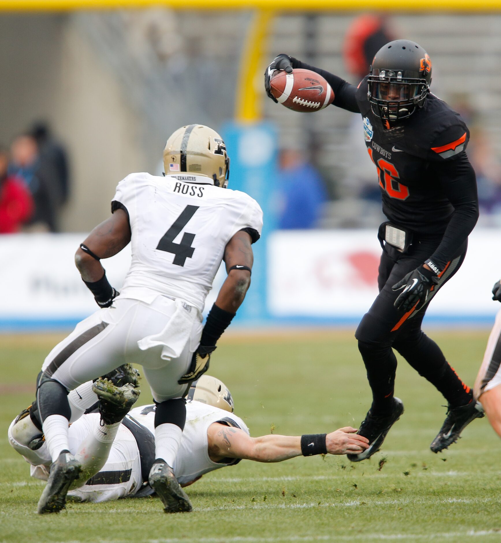 Oklahoma State's Andrae May (16) breaks Purdue's tackle attempts after picking up a fumble...