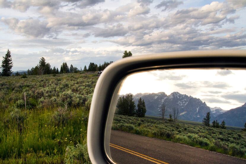 The Teton Range reflected in the rear-view mirror during a road trip through Wyoming, June...