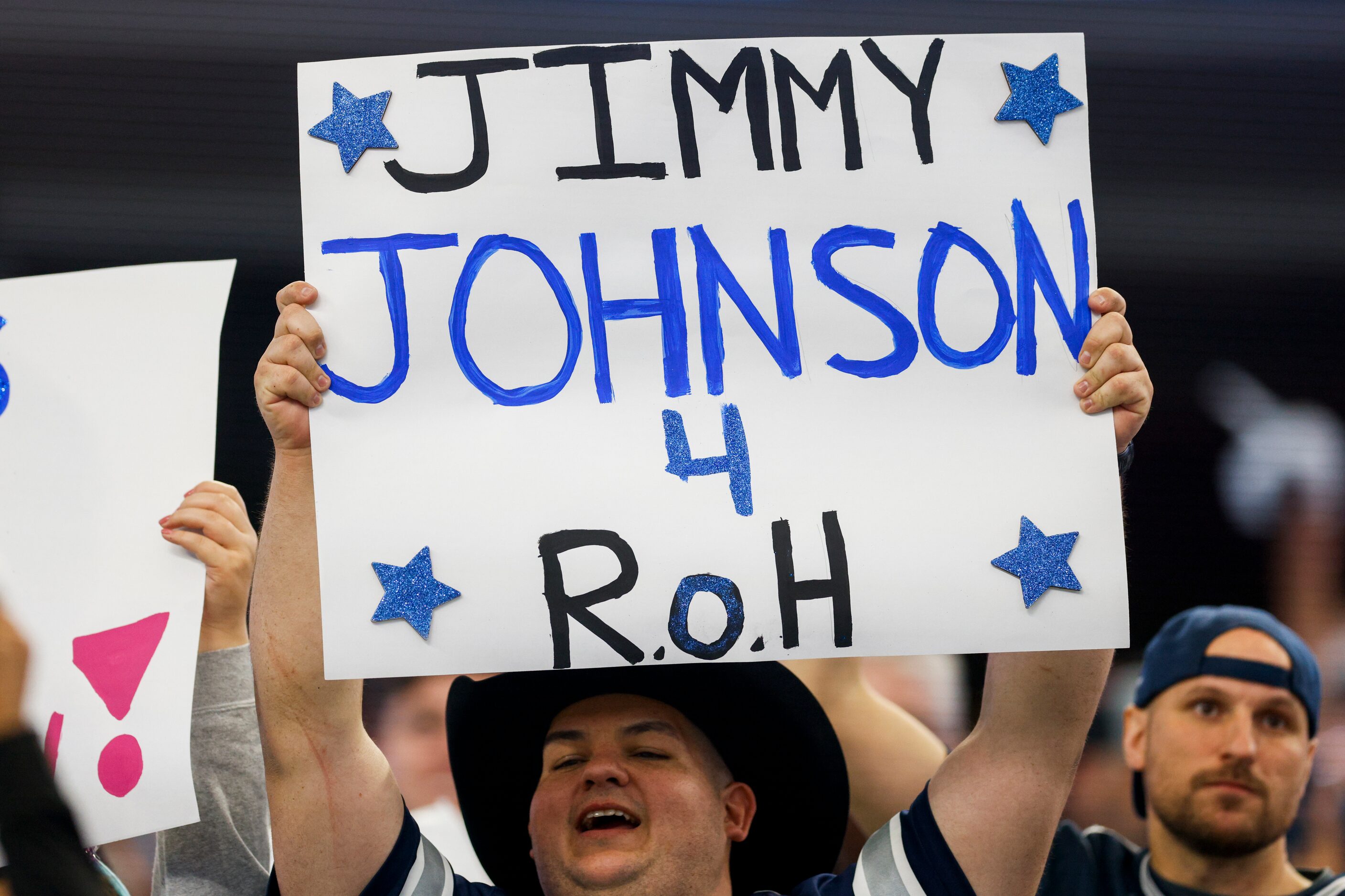 A fan raises a sign advocating for former Dallas Cowboys head coach Jimmy Johnson to be...