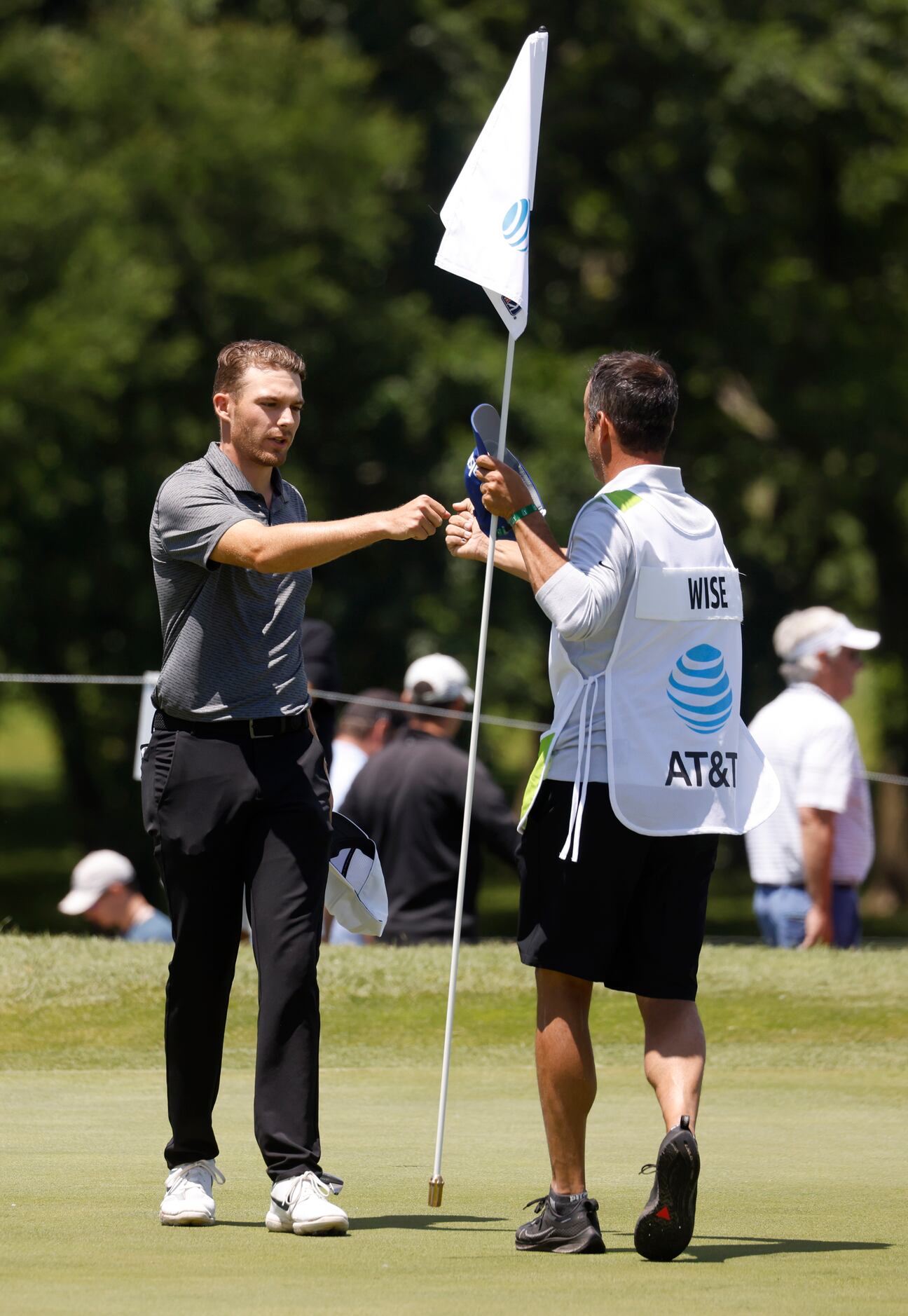 Aaron Wise bumps fists with his caddie after finishing -8 on the 18th hole during round 1 of...