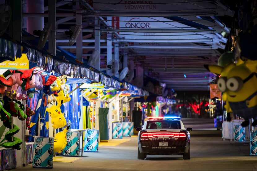 A Dallas police cruiser patrols the empty midway after closing at the State Fair of Texas.