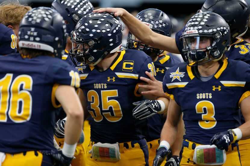Highland Park's Paxton Alexander (35) is congratulated by his teammates after he returned a...