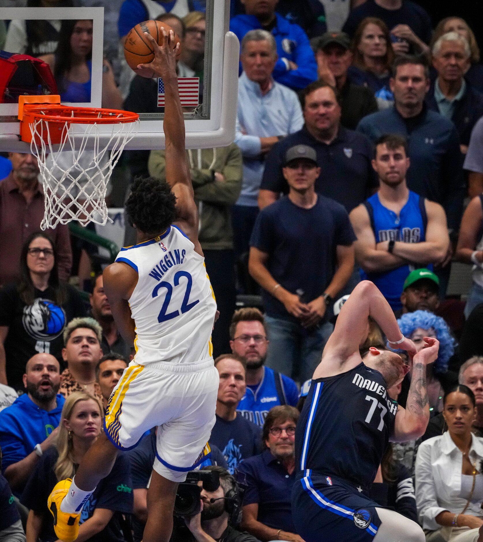 Dallas Mavericks guard Luka Doncic (77) is knocked backwards on a dunk by Golden State...